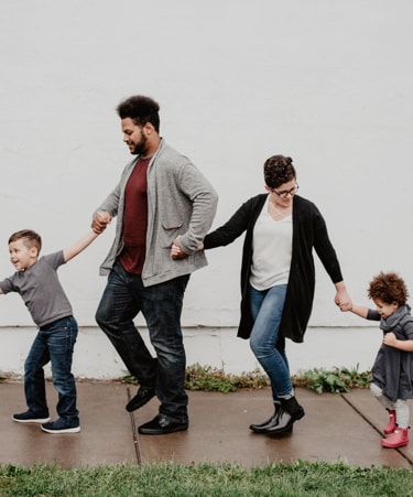 four people of a family holding each other hands